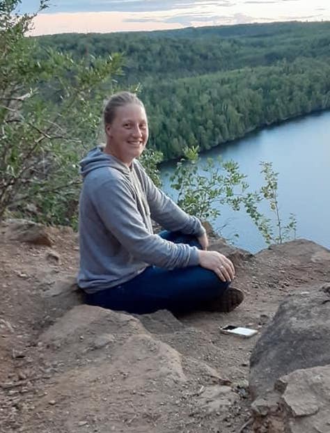 Christy Miller sitting on a rock overlooking the lake