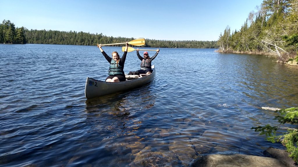 two women in a canoe on a lake