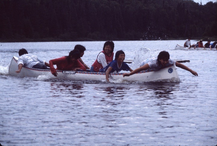 native american youth having fun in a canoe