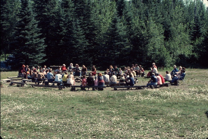 people gathered in a circle outside for Sunday worship