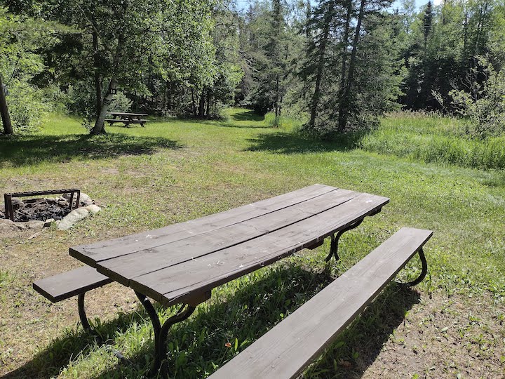 the picnic table, firepit and tent area in Campsite 10