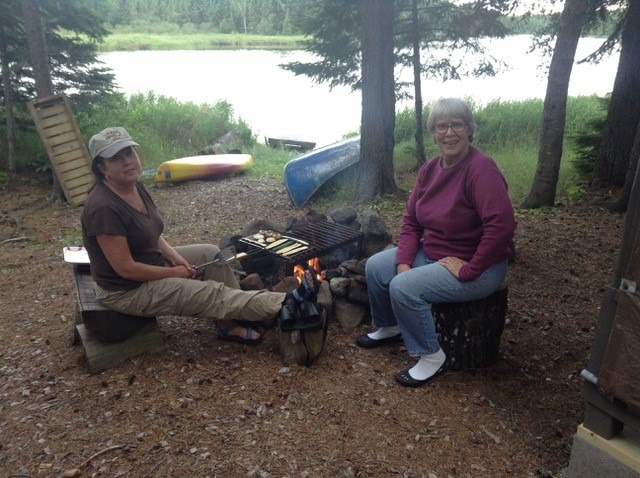 Two people sitting around campfire