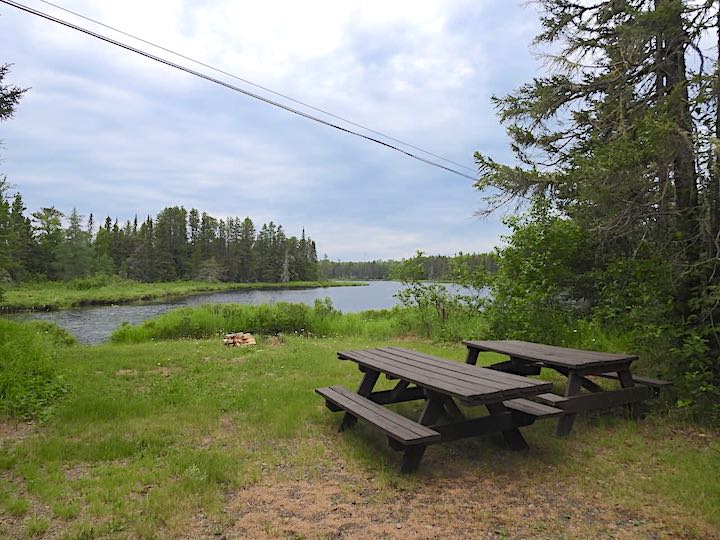 Group Site 32 picnic tables and fire ring by lake