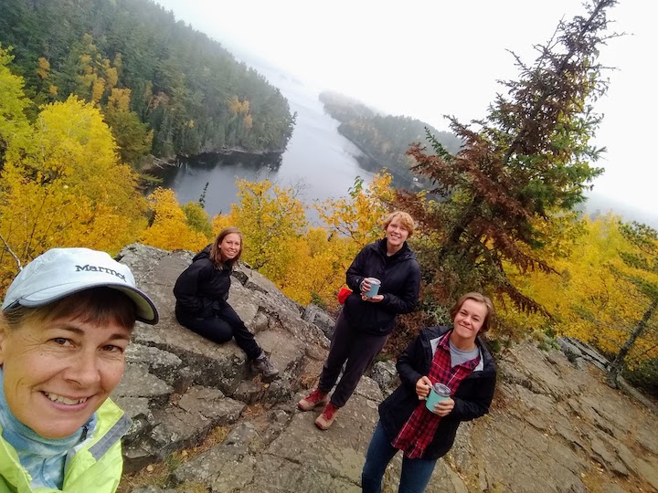 four women on a rock above West Bearskin Lake on Caribou Rock hike