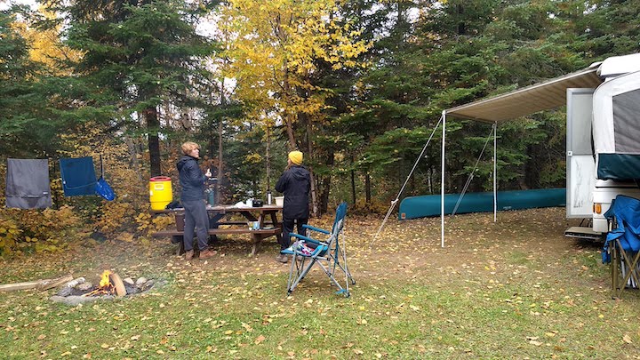 two women at an Okontoe campsite with a popup camper in the fall