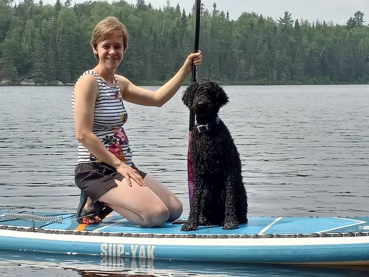 young woman and her dog on a paddle board on Bow Lake at Okontoe