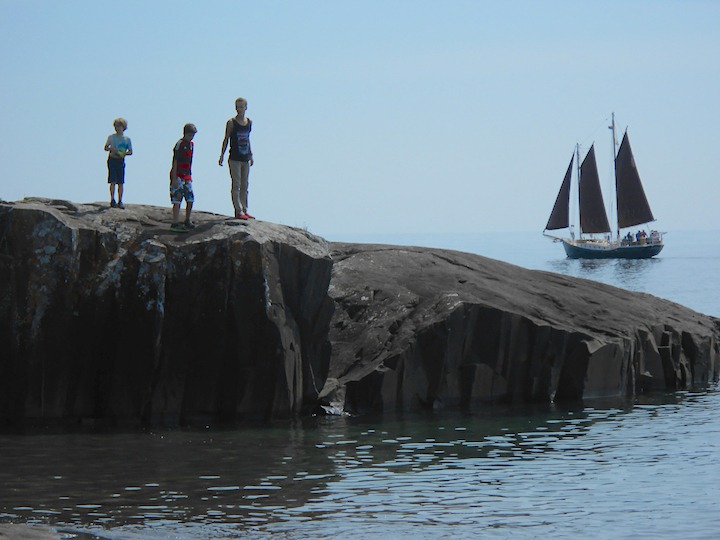 three boys at Artist's Point in Grand Marais, sailing ship in the background