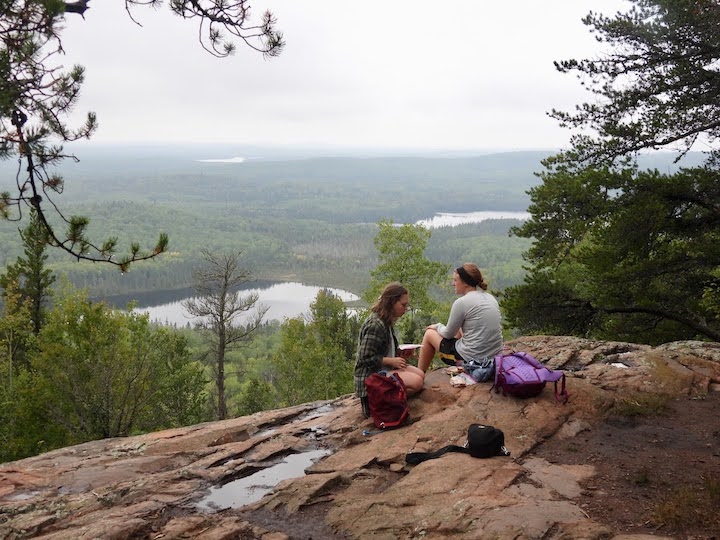 two women sit at a rocky overlook of Eagle Mountain