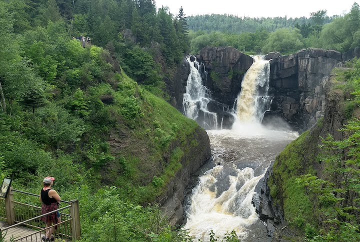 woman overlooks the High Falls of the Pigeon River at the US/Canada border
