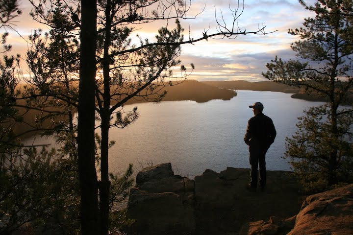 man overlooks Hungry Jack Lake at sunset from Honeymoon Bluff