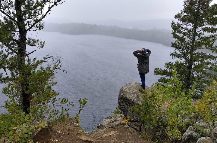 woman overlooks a big lake in the rain