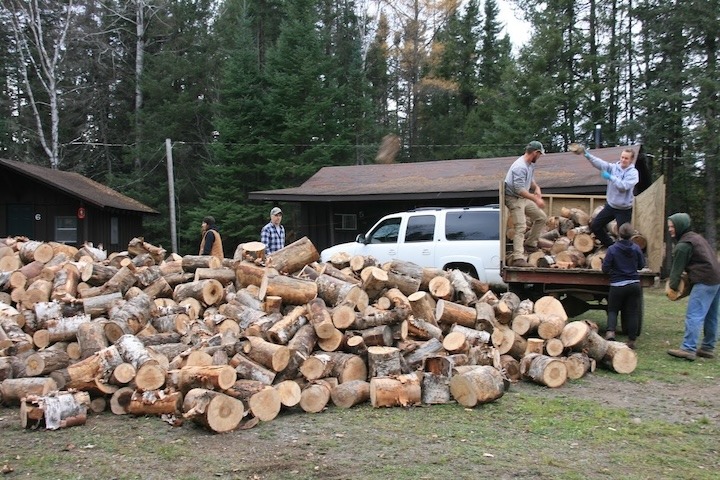 several people hauling cut firewood at Okontoe