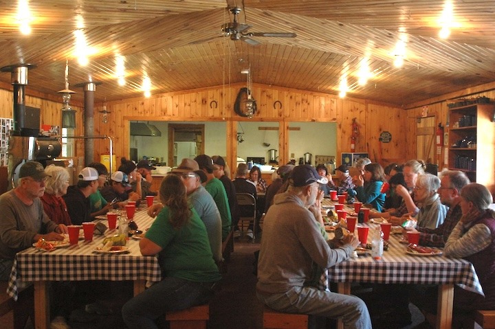 group eating a meal at two long tables in Okontoe's dining hall