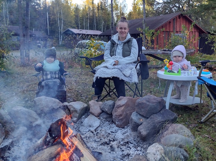 a mom and two young children at a morning campfire at Okontoe