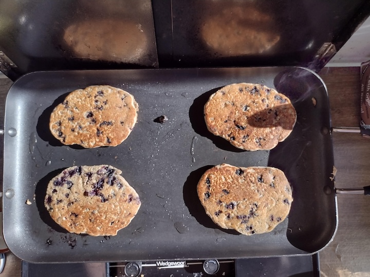 pancakes with wild blueberries cook on a campstove