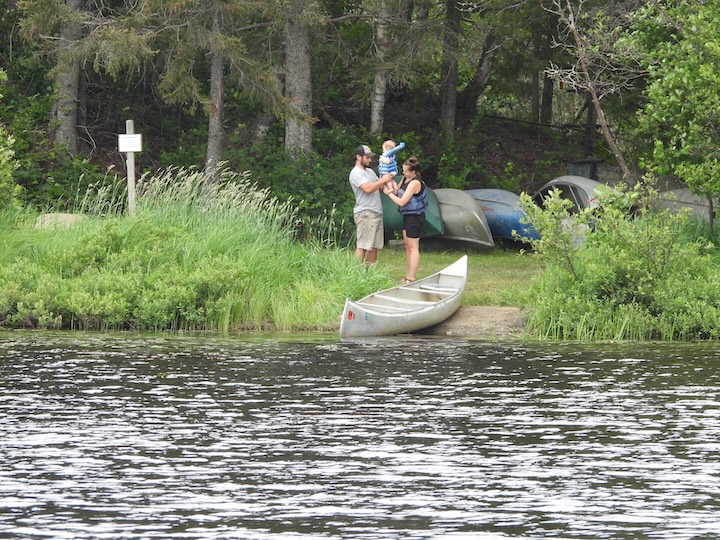 man and woman get their baby ready for a canoe ride at Okontoe