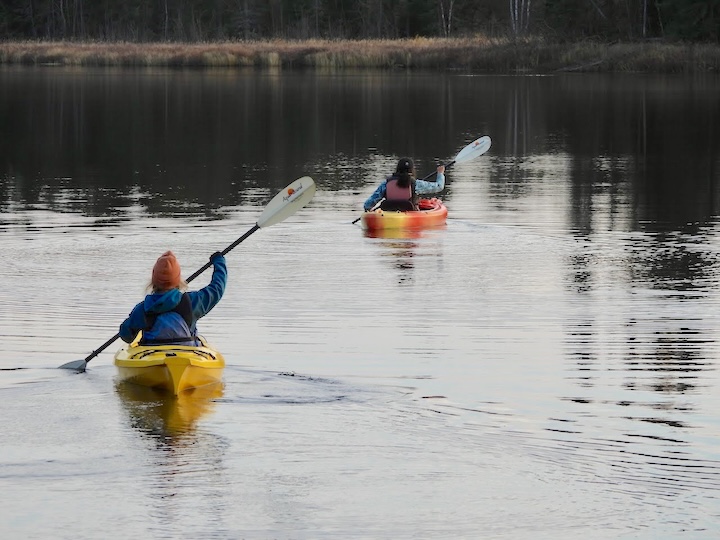 two women kayak on bow lake