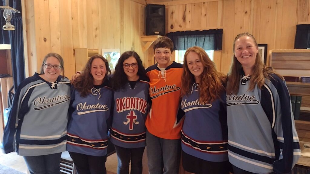 a group of smiling young men and women wearing Okontoe hockey jerseys