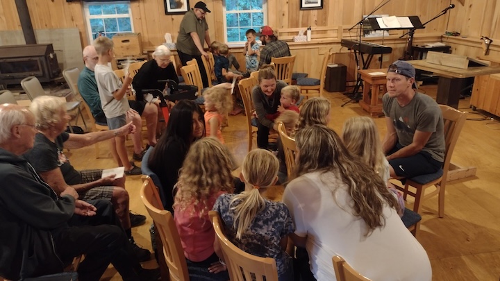 a group of adults and kids inside the Okontoe Chapel building