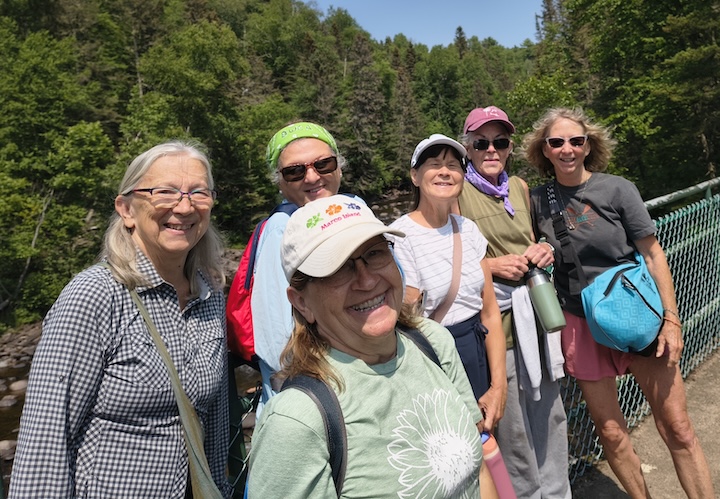 six women pose during a hike